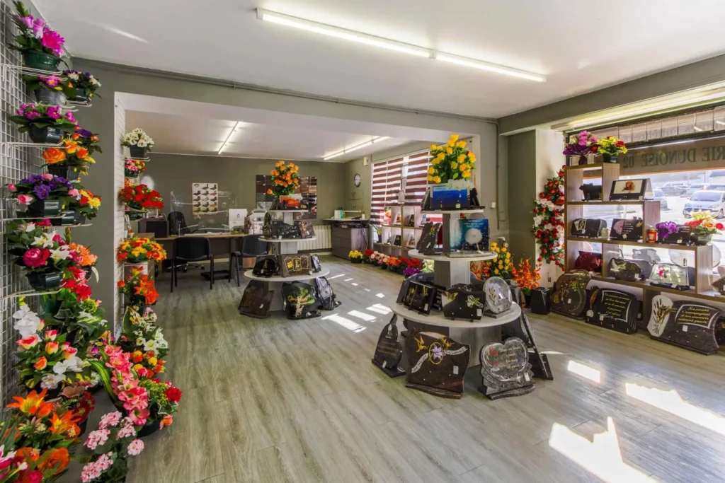 Intérieur du magasin : plaques funéraires personnalisables et fleurs artificielles.